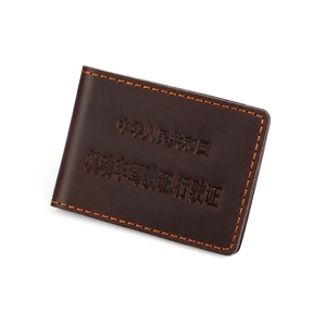 Macro shot of dark brown leather driver's license holder with detailed orange stitching