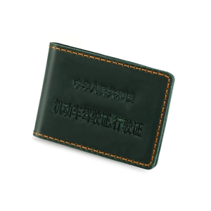 Detailed view of dark green leather wallet with orange contrast stitching and embossed text