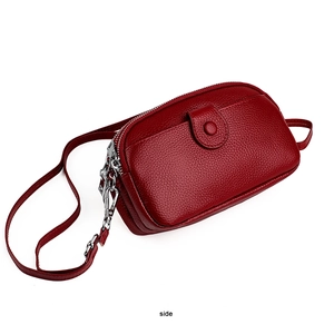 Vue latérale du sac à bandoulière en cuir grainé rouge foncé avec double fermeture éclair
