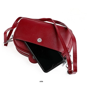 Vue latérale du sac à bandoulière en cuir rouge foncé montrant la poche pour téléphone