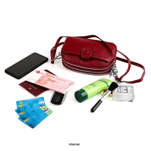 Vue détaillée du sac à bandoulière en cuir rouge montrant les compartiments et le rangement