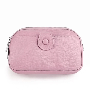 Détail d'un sac à bandoulière en cuir rose avec poche à bouton-pression et fermeture éclair