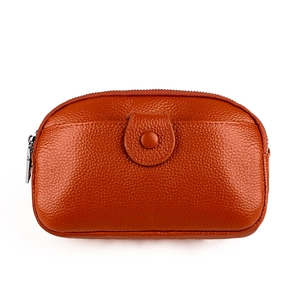 Gros plan sur un sac de téléphone en cuir caramel avec texture grainée et fermoirs argentés