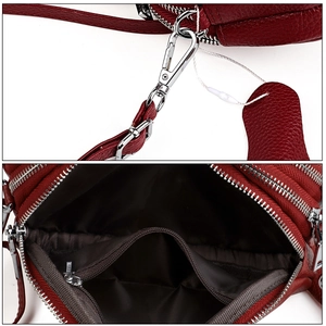 Détails du sac bandoulière en cuir bordeaux avec ferrures argentées et poche zippée interne