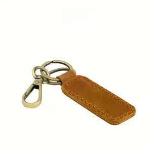Detail of vintage brown crazy horse leather keychain with brass metal horseshoe D-ring