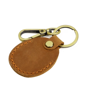 Macro view of vintage brown leather keychain with orange stitching and brass hardware