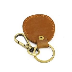 Detailed close-up of brown leather keychain with bronze metal ring and lobster clasp hook