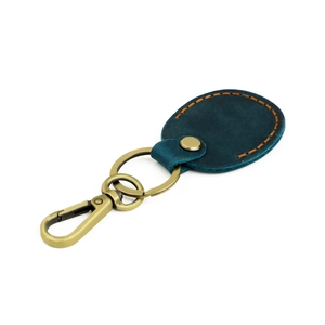 Detail of teal leather key fob with orange stitching and vintage brass spring hook