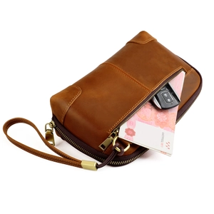 Detailed side view of vintage brown leather clutch bag with wrist strap and metal zipper