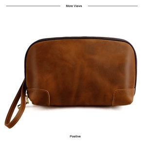 Detail of vintage brown leather clutch with metal zipper and wrist strap for accessories