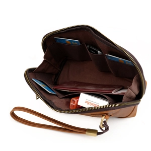 Vintage brown leather clutch bag with card slots and wrist strap shown from a 45-degree angle