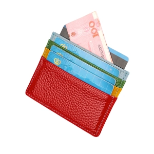 Detail view of red lychee leather card holder with multiple colorful gradient slots
