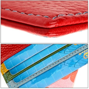 Macro detail of red lychee grain leather wallet with multi-color card slots and blue stitching