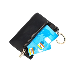 Detail of black leather coin purse with orange stitching and vintage key ring