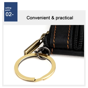 Detail of leather key pouch featuring contrast yellow stitching and a golden key ring