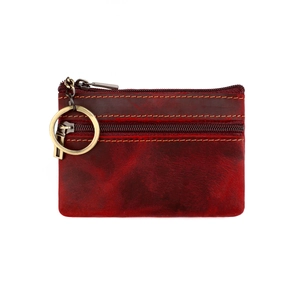 Detail of dark red vintage genuine leather coin purse with yellow stitching and key ring