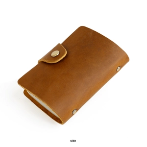 Close-up side view of retro brown genuine leather wallet with vintage metal snap button
