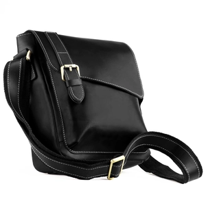 Detail view of premium leather crossbody bag showing contrast stitching and brass buckle