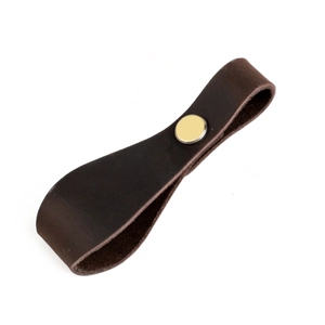 Close-up of vintage brown leather drawer handle with a classic brass metal rivet