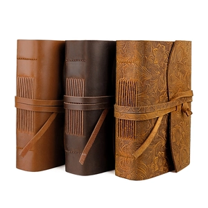 Three handmade vintage leather notebooks with embossed floral patterns and cord closures