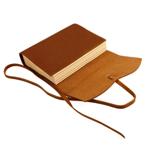 Macro view of vintage crazy horse leather cover with wrap-around strap and thick kraft paper
