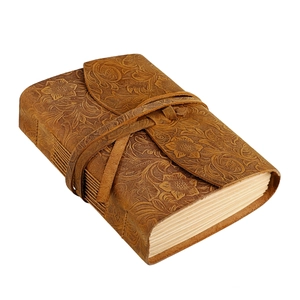 Detail view of vintage embossed floral leather cover and tie closure for notebook