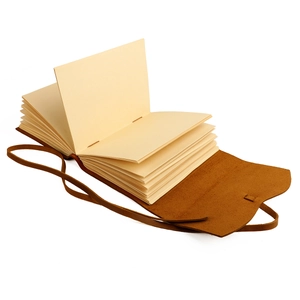 Detail of vintage handmade leather diary with thick cream pages and a wrap tie closure