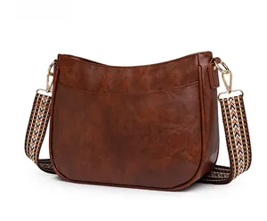 Dettaglio borsa a tracolla marrone vintage con tracolla intrecciata e fibbie dorate