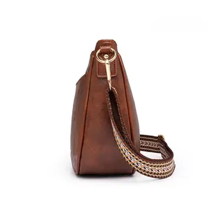 Vista laterale borsa tote retrò marrone con ampia tracolla in tessuto stile etnico