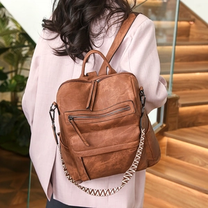 Détail du sac à dos marron en cuir PU vintage avec sa bandoulière tissée géométrique