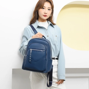 Detail of navy blue lychee-pattern leather backpack with side metal eyelet puller