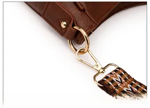 Dettagli della borsa vintage con fibbie dorate e tracolla intrecciata in stile etnico