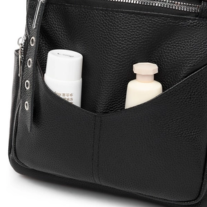 Detail view of large capacity black PU leather backpack showing front pocket storage