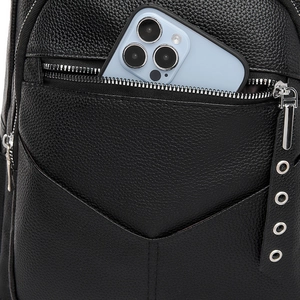 Detail of black pebbled leather backpack with a front zipper pocket holding a smartphone