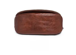 Close-up of retro brown leather texture and bronze zipper detail on the bag bottom
