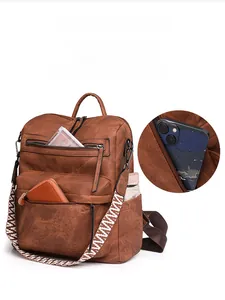 Detail of brown vintage PU leather backpack showing side pocket storage and woven strap
