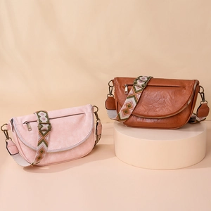 Detail of crossbody bags with ethnic patterned wide straps in pink and brown leather