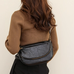 Close-up of black PU leather half-moon crossbody bag with bohemian printed wide strap