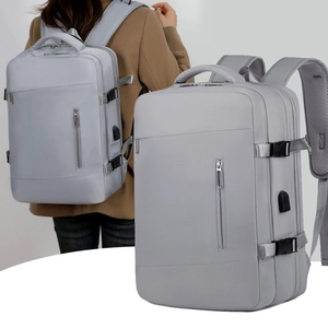 Detail of grey expandable travel backpack with multi-layer zipper compartments and side buckles