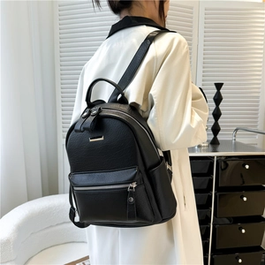 Minimalist black faux leather backpack for women shown on model for daily commuting