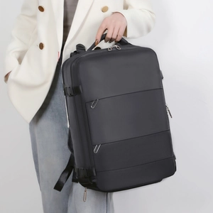 Handheld view of black business backpack showing large capacity and waterproof fabric