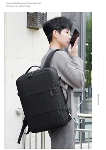 Detail of black business travel backpack showing external USB charging port and cable