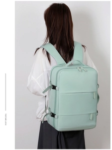 Detail of mint green travel backpack with multiple compartments and side buckles
