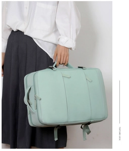Detail view of large mint green travel backpack with side handles and buckles