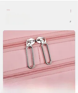 Detailed macro view of smooth dual-direction pink nylon backpack zippers with silver metal pulls