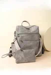 Dettaglio zaino vintage in tela grigia con chiusure lampo e spallacci in tessuto jacquard