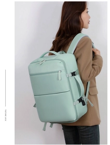 Detail view of mint green travel backpack showing side handle and reinforced buckles