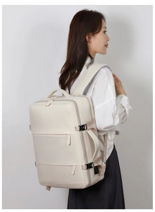 Detail view of cream white travel backpack showing side handle and adjustable straps