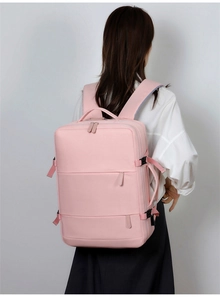 Pink multipurpose travel backpack with side buckle and carrying handle on a model