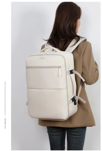 Rear view of cream multi-functional travel backpack with laptop compartment on model